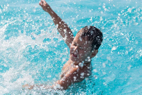 Pojken simmar i poolen — Stockfoto