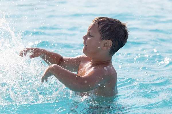 Pojken simmar i poolen — Stockfoto