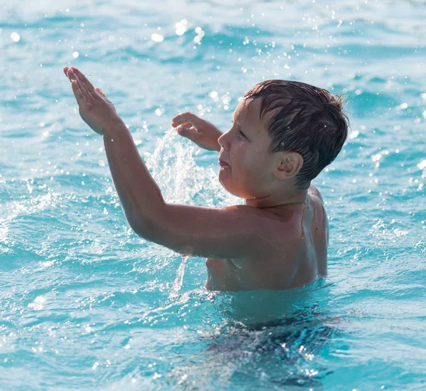 Pojken simmar i poolen — Stockfoto