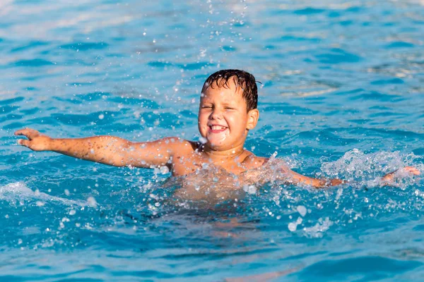 O menino está nadando na piscina — Fotografia de Stock