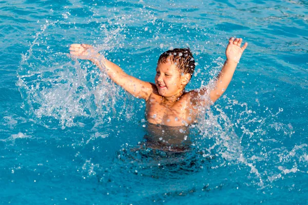 Pojken simmar i poolen — Stockfoto