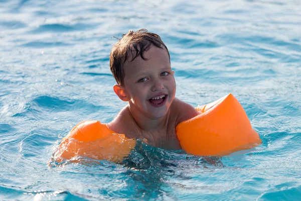 Pojken simmar i poolen — Stockfoto