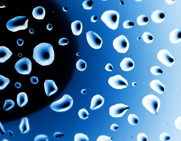 Droppar vatten på en blå bakgrund — Stockfoto