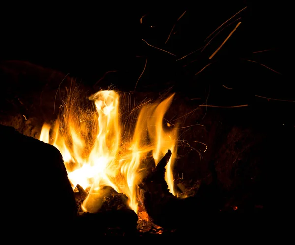 黑色背景上喷出火花的火焰 — 图库照片