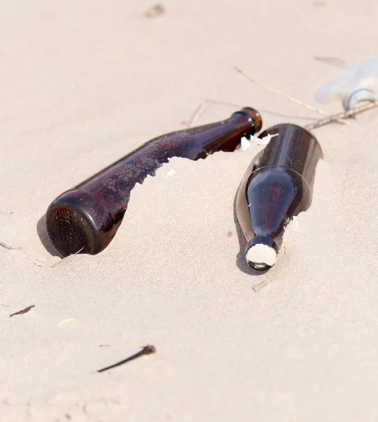Glass bottles in the sand on nature. trash — Stock Photo, Image