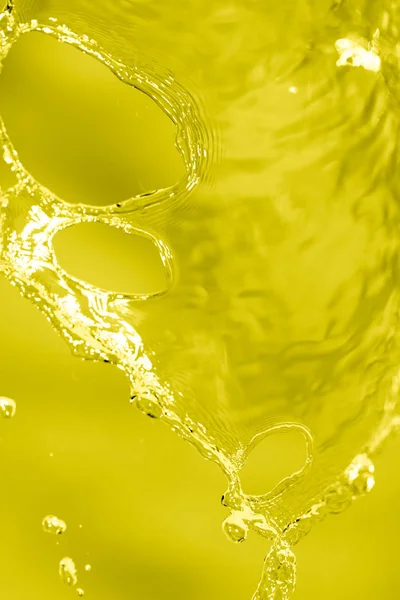 Spruzzi d'acqua su fondo giallo — Foto Stock