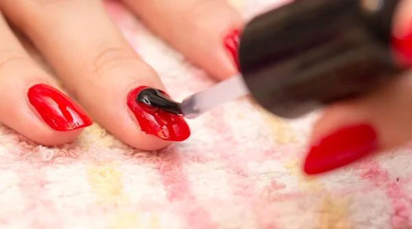 Ногти окрашены в красный лак для ногтей в салоне красоты — стоковое фото