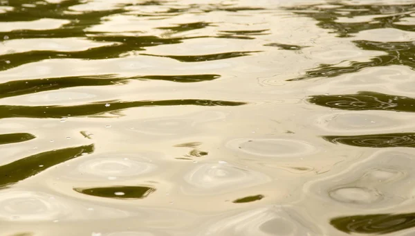 Fondo de la superficie amarilla del agua — Foto de Stock