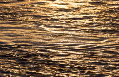 Gün batımında su yüzeyi arka