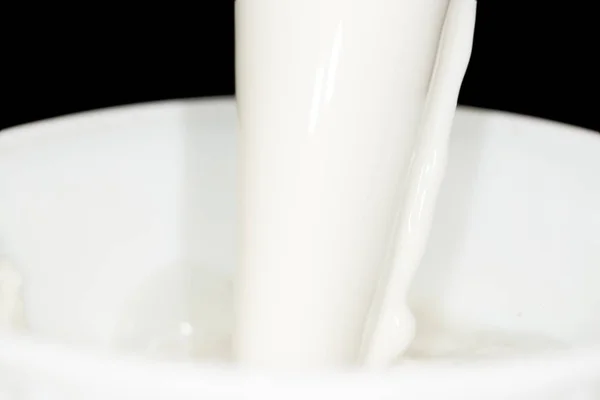 Salpicadura de leche sobre fondo negro — Foto de Stock