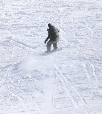 İnsanlar kışın karda snowboard yapıyor.
