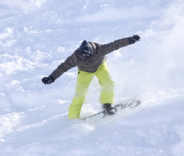 İnsanlar kışın karda snowboard yapıyor.