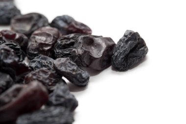 Beyaz arka planda siyah kuru üzüm. makro