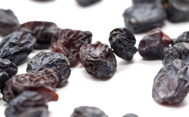 Beyaz arka planda siyah kuru üzüm. makro