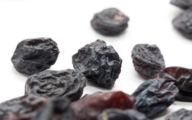 Beyaz arka planda siyah kuru üzüm. makro