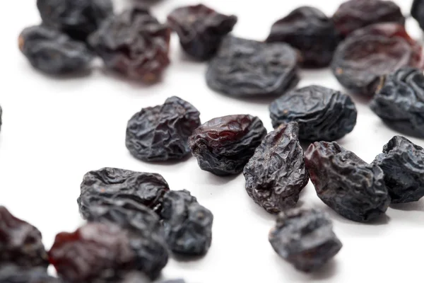 Black raisins on a white background. macro — Stock Photo, Image