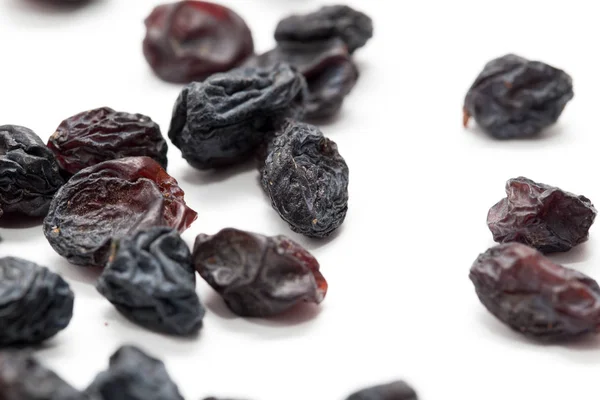 Black raisins on a white background. macro — Stock Photo, Image