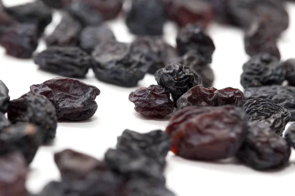 Black raisins on a white background. macro — Stock Photo, Image
