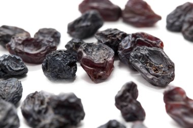 Beyaz arka planda siyah kuru üzüm. makro