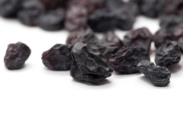 Black raisins on a white background. macro — Stock Photo, Image