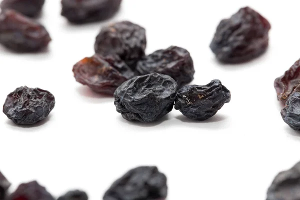 Black raisins on a white background. macro — Stock Photo, Image