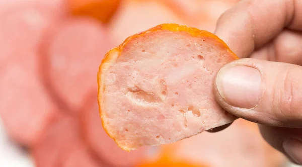 Свіжа нарізана ковбаса в твоїй руці — стокове фото