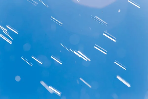 Gocce di pioggia su uno sfondo di cielo blu — Foto Stock