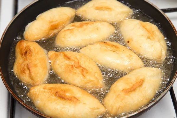 Rissóis de comida em uma panela de ato de fritar — Fotografia de Stock