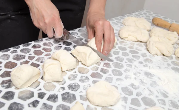 Cortar la masa con un cuchillo en la cocina — Foto de Stock