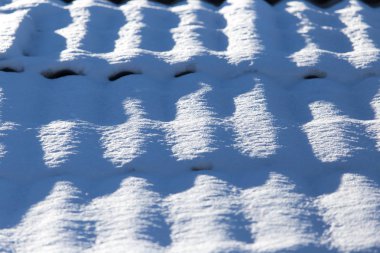 Arka plan olarak bir evin çatısında kar var.