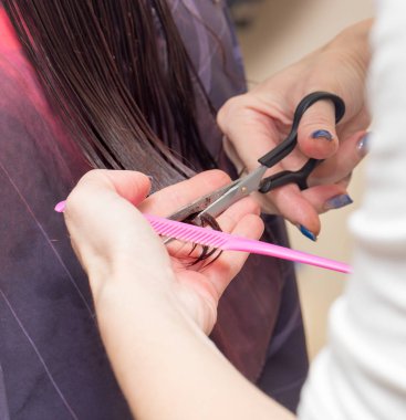 Güzellik salonunda makas kesen bir kadın.