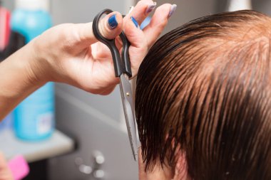 Güzellik salonunda makas kesen bir kadın.