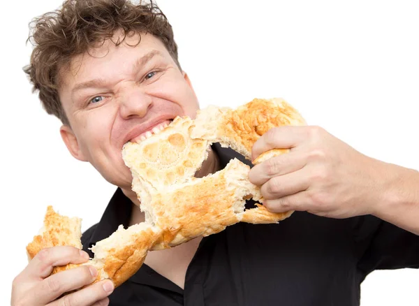 Hombre come pan sobre un fondo blanco — Foto de Stock