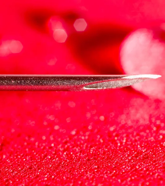 Syringe needle on a red background. close — Stock Photo, Image