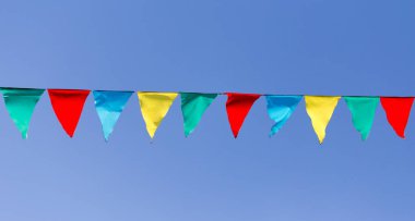 mavi gökyüzüne karşı çok renkli bayraklar