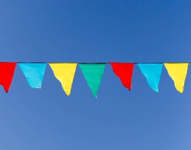 mavi gökyüzüne karşı çok renkli bayraklar