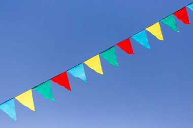 mavi gökyüzüne karşı çok renkli bayraklar