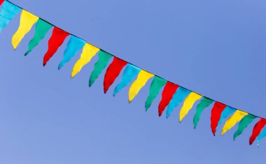 mavi gökyüzüne karşı çok renkli bayraklar