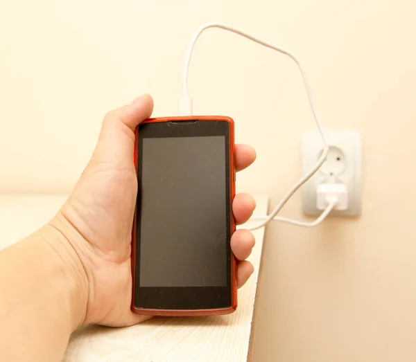 Cell phone charging in your hand — Stock Photo, Image