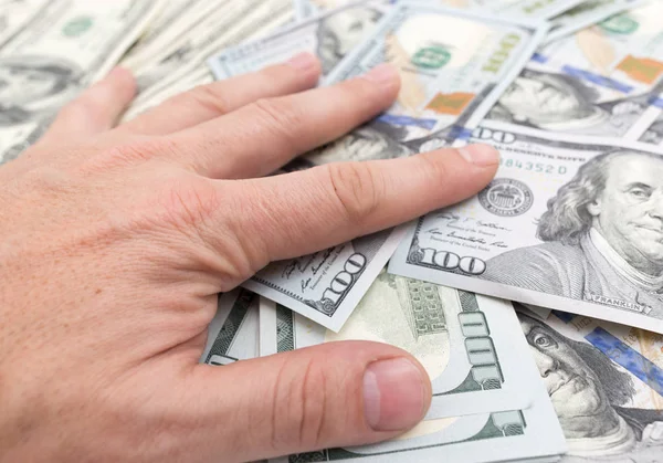 Hand on a pile of dollars — Stock Photo, Image