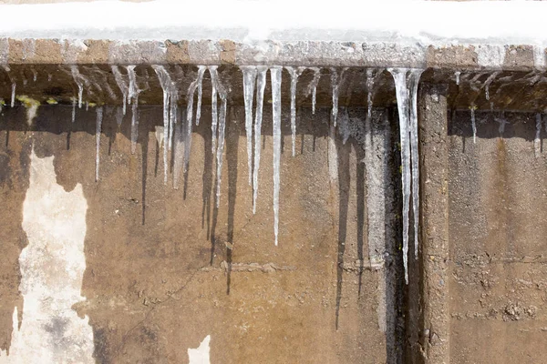 Baharda evin çatısında büyük buz sarkıtları asılı. — Stok fotoğraf