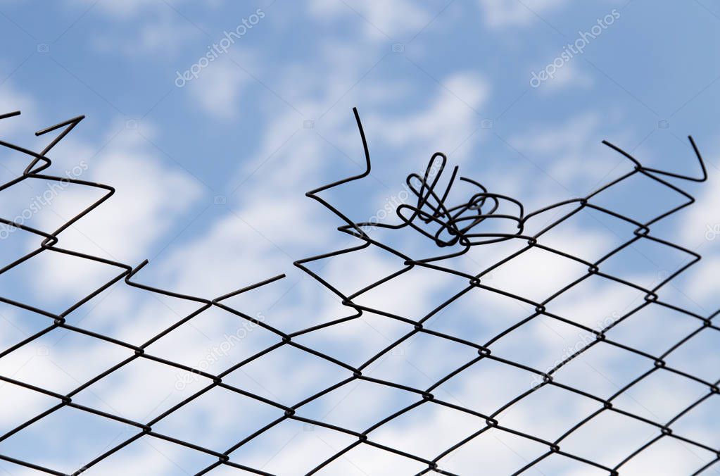 metal fence against the blue sky with clouds