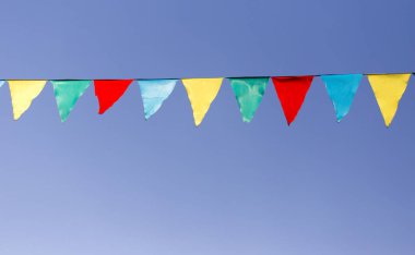 mavi gökyüzüne karşı çok renkli bayraklar