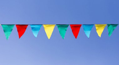 mavi gökyüzüne karşı çok renkli bayraklar