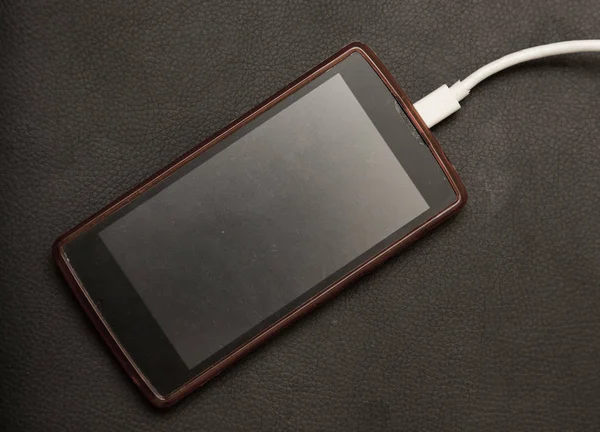 Phone charging on a black background — Stock Photo, Image