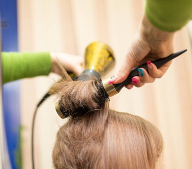 Kuaför saç kurutma makinesini kurutur.