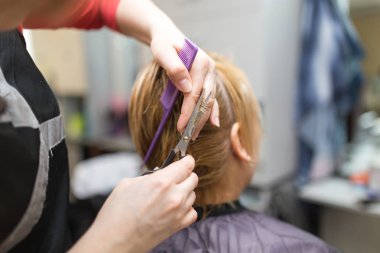 Güzellik salonunda makas kesen bir kadın.