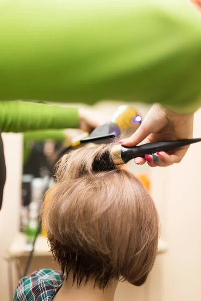 Frisör torkar hårtorken blont hår — Stockfoto