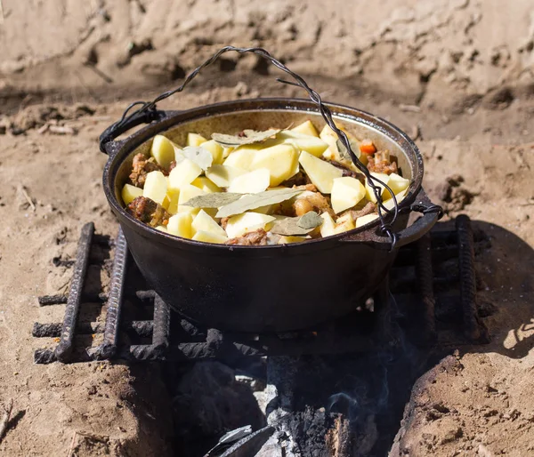 La carne con las patatas en el caldero a fuego — Foto de Stock