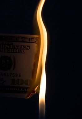 Siyah arka planda yanan 100 dolar.